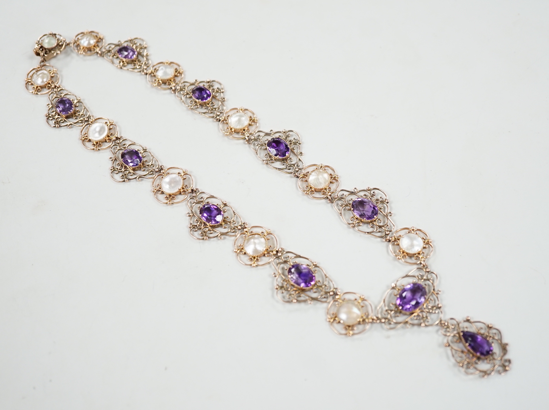 An Edwardian yellow metal, amethyst and mother-of-pearl set drop necklace, 44cm, gross weight 29.5 grams.